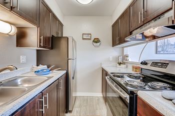 A kitchen with a stove top oven and a refrigerator.